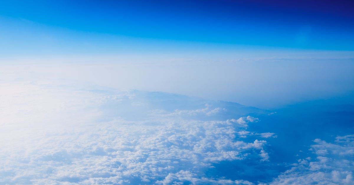 Stunning aerial view showcasing bright blue sky above a sea of fluffy clouds.